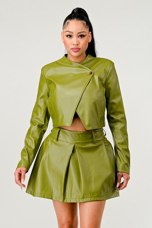 Woman wearing a green leather jacket and skirt co-ord set on a white background