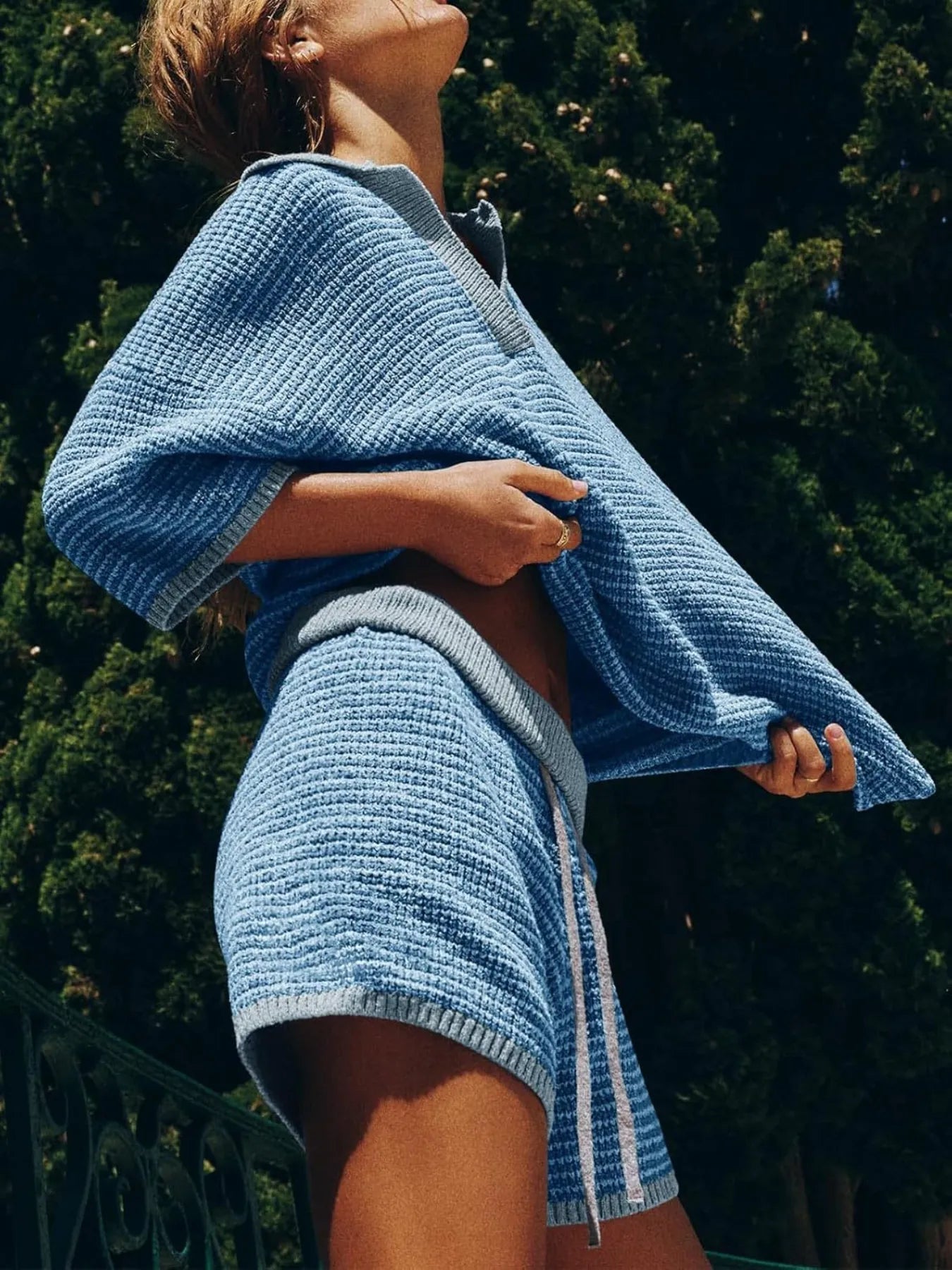 woman wearing a blue collared contrast striped knit top and matching shorts two piece casual set.