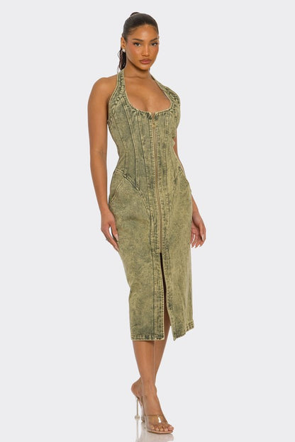 Woman wearing a green acid wash Halter denim midi dress with backless design and front slit on a white background