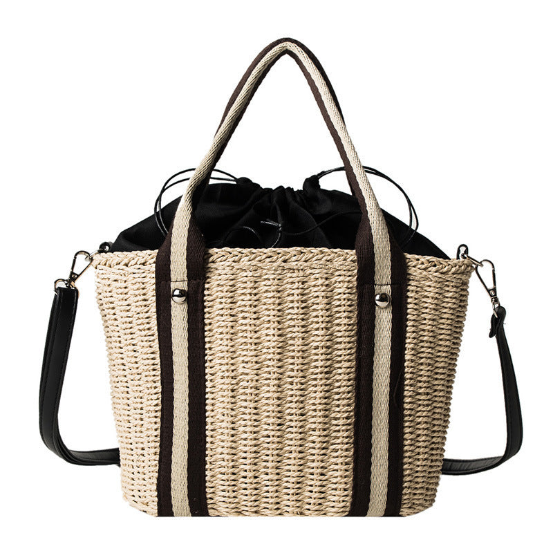 Woven straw shoulder bag with contrast strap on a white background