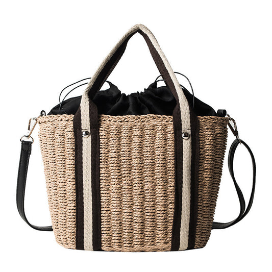 Woven beach bag with black drawstring and contrast straps on a white background