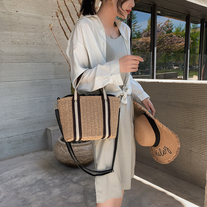 Woman holding a straw woven beach bag and straw hat in an outdoor setting