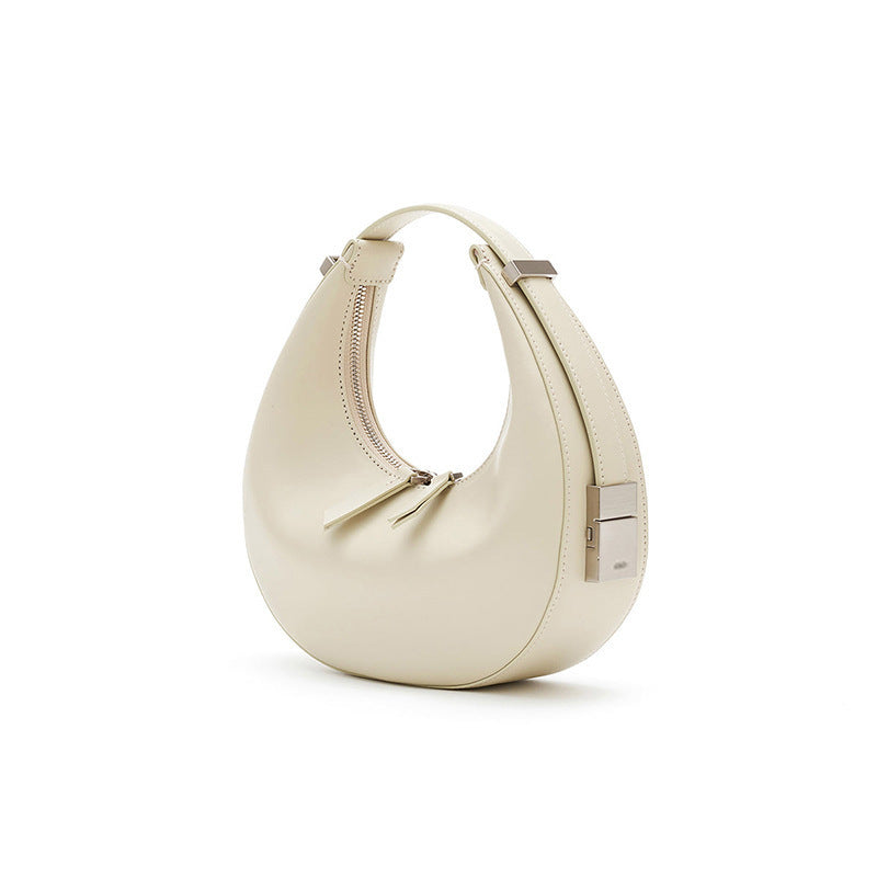 Beige genuine leather crescent shoulder handbag with silver polished hardware on a white background
