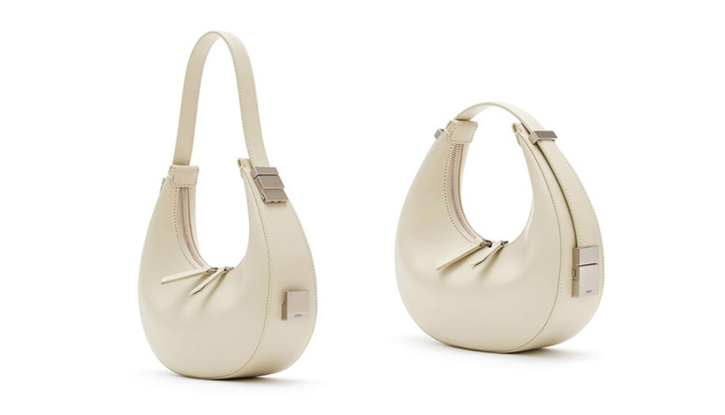 beige/off white genuine leather shoulder handbag showing adjustable handle on a white background