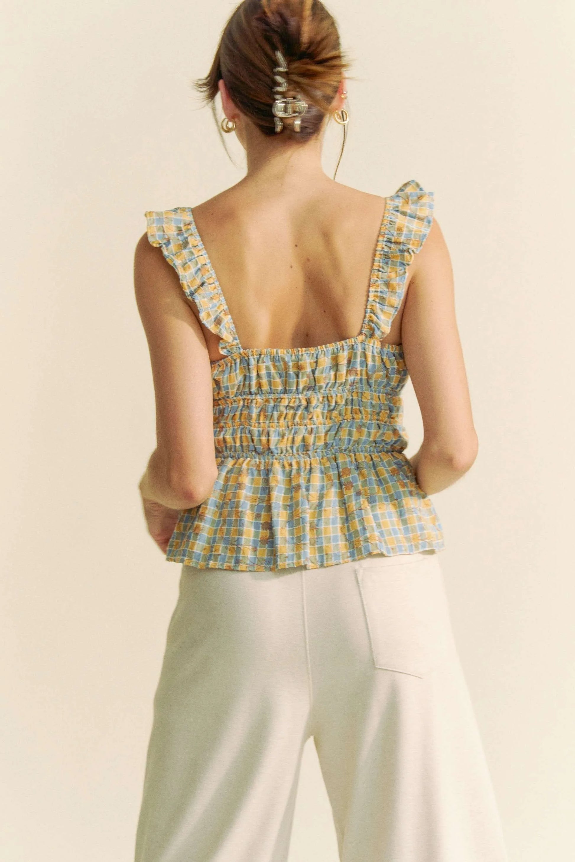 Model wearing plaid smocked top with ruffle straps back view
