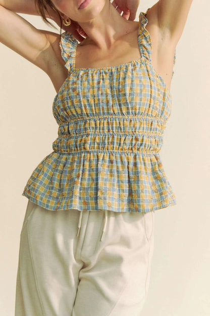 Model wearing plaid smocked top with and cropped fit front view with arms up
