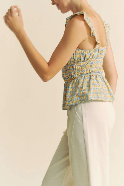 Model wearing plaid smocked top with ruffle straps side view
