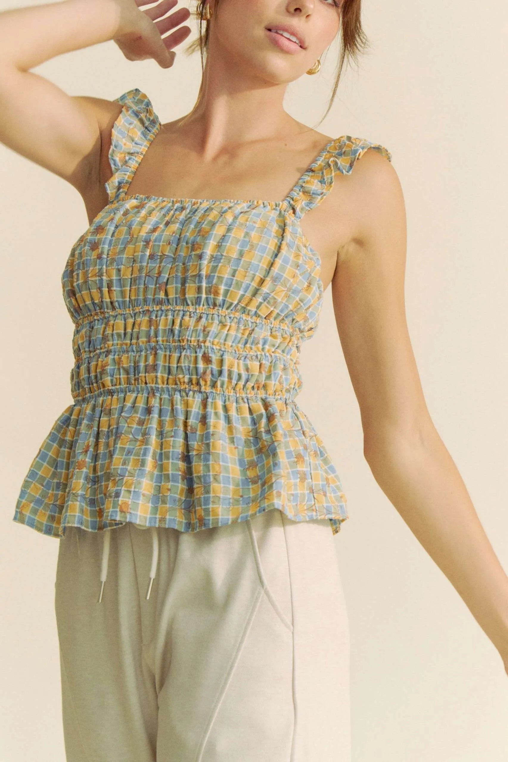 Model wearing plaid smocked top with ruffle straps front/side view
