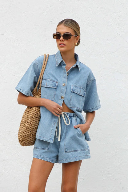 Woman wearing a Two-piece denim shirt and shorts summer co-ord against a white background