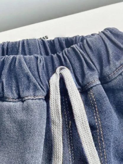 Close-up of blue denim summer shorts with a drawstring on a white background