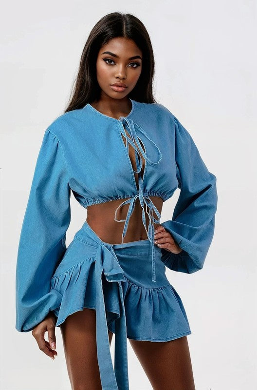 woman posing in a blue denim two-piece cropped top and ruffle skirt set 
