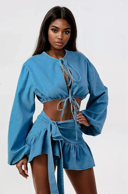 woman posing in a blue denim two-piece cropped top and ruffle skirt set 