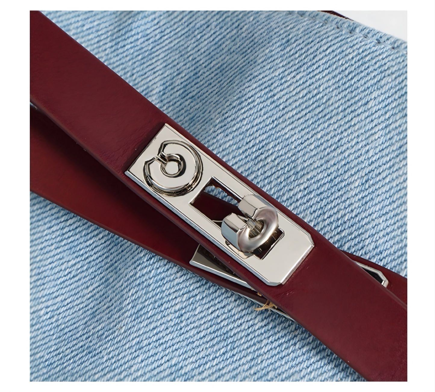 Close-up of a red genuine leather accent for Denim & Genuine Leather Contrast Tote Bag with a silver buckle