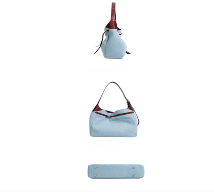 Side, bottom, and back view of light blue denim shoulder tote handbag with burgundy genuine leather accents on a white background