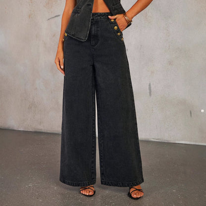 Woman wearing black wide-leg high rise jeans with gold buttons on a gray background