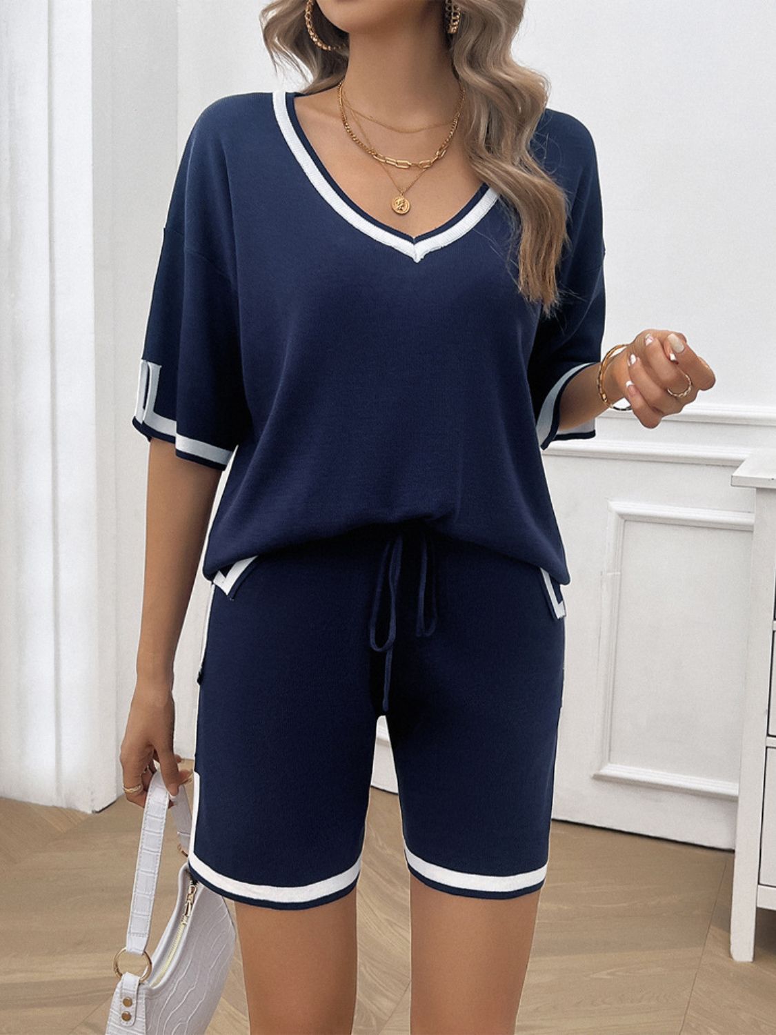 Soft fabric women's loungewear set with V-neck top dark blue on model holding a white purse
