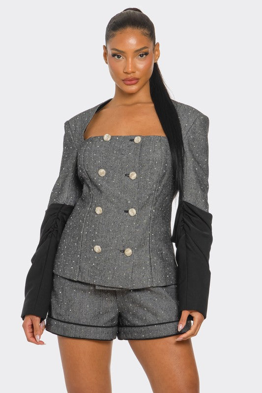 Woman wearing gray and black tweed blazer and high waist shorts tailored two piece set with shimmer detail on a white background front view
