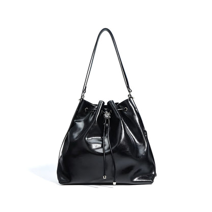 Black genuine leather bucket shoulder handbag with drawstring closure on a white background front view