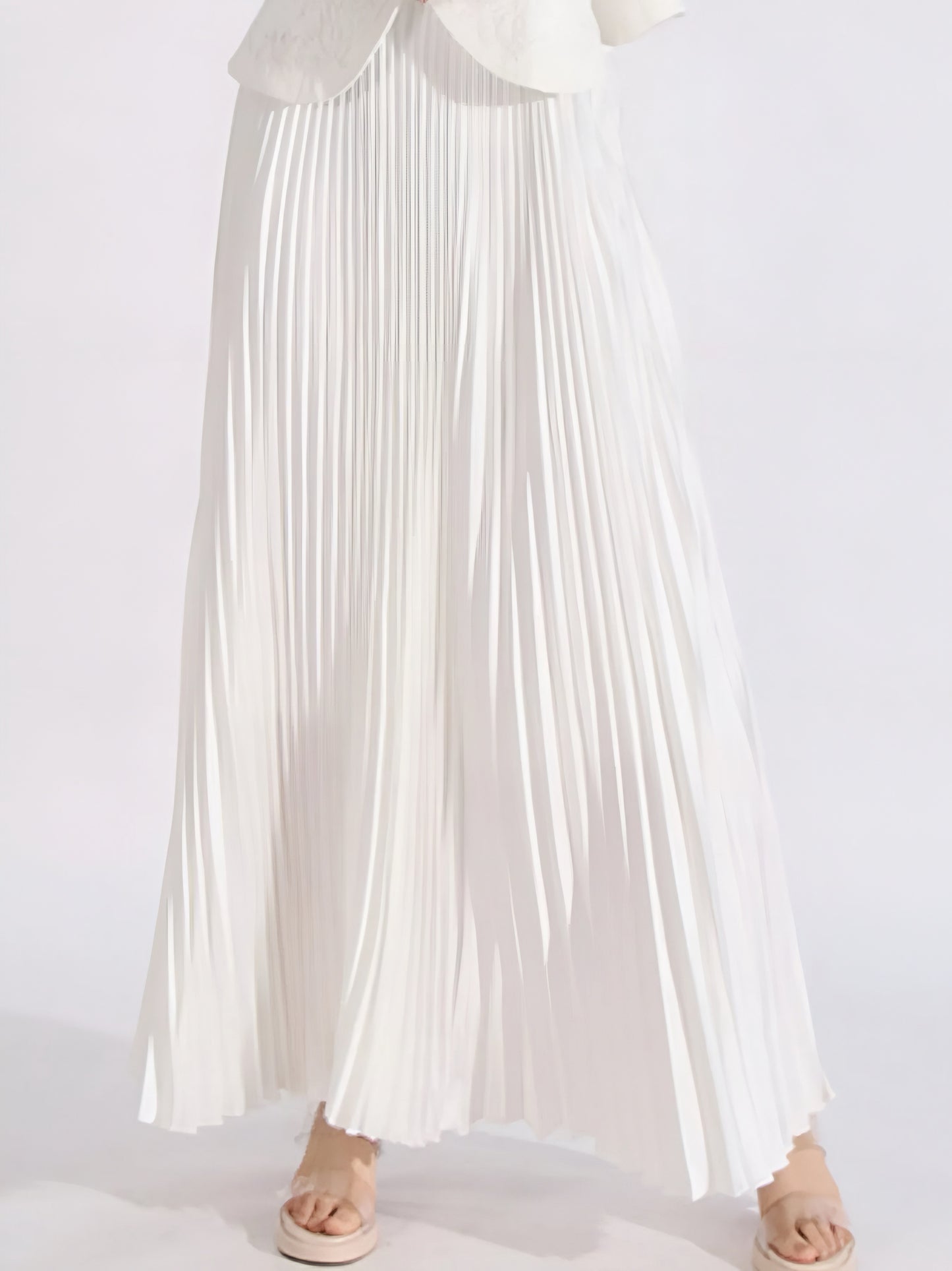 White flowy pleated skirt of elegant two piece suit set for women on a white background