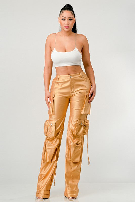 front view of woman wearing gold trendy PU leather pants with oversized 3D utility pockets on a white background-cruelty free fashion