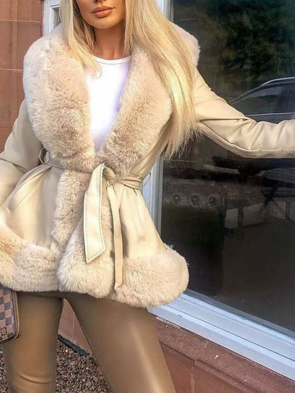 woman wearing a beige coat with fur trim in front of a window.