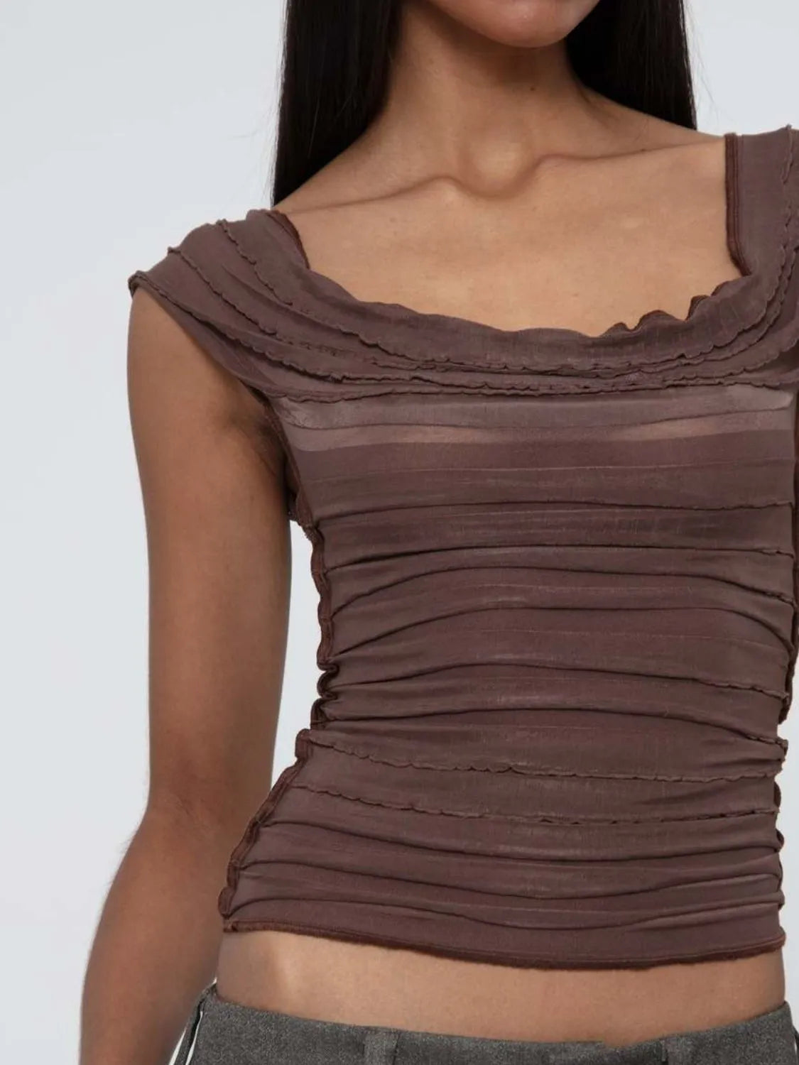 Brown ruched sleeveless top worn by a model on a white background