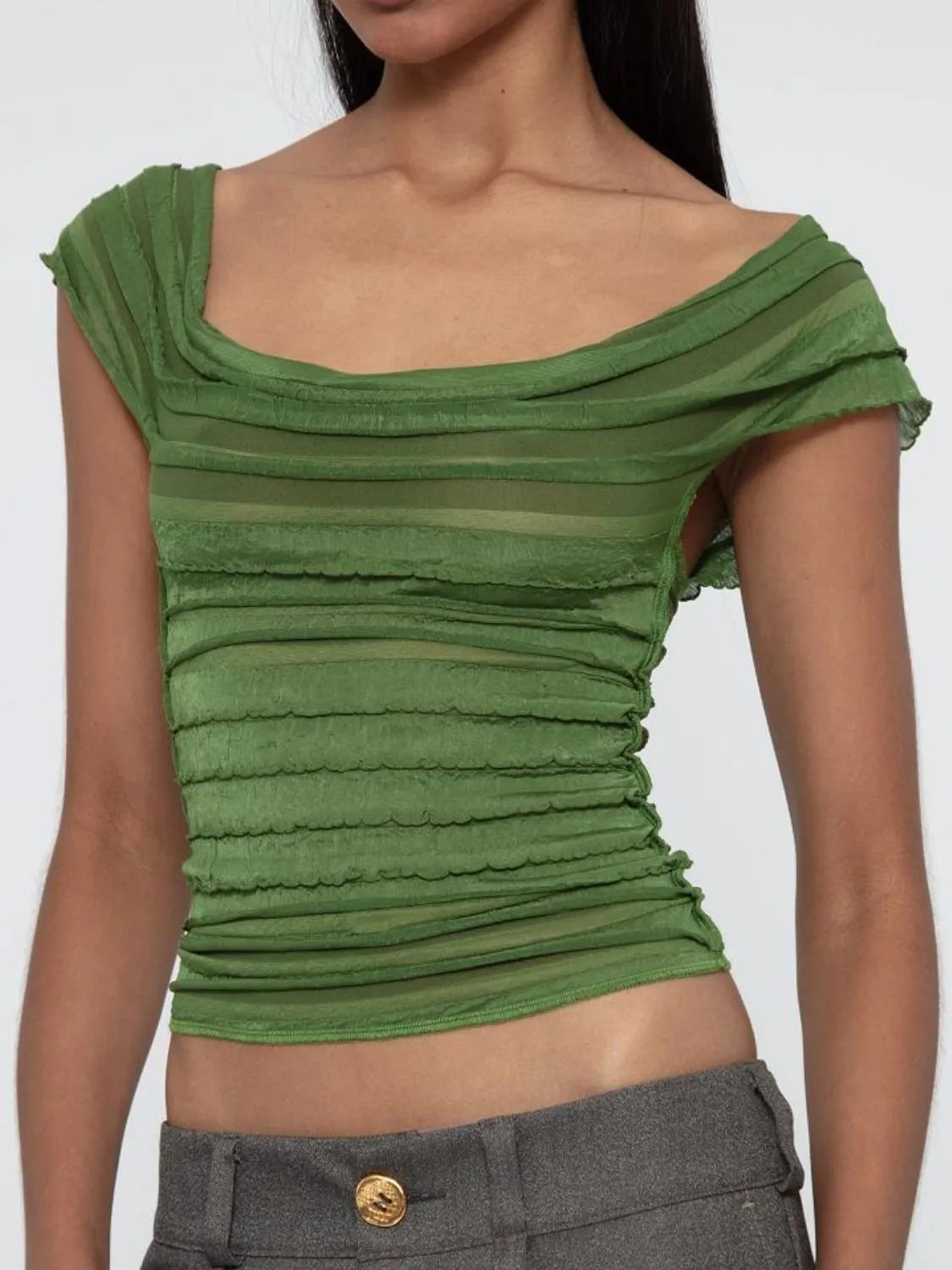 Green ruched sleeveless top worn by a model on a white background