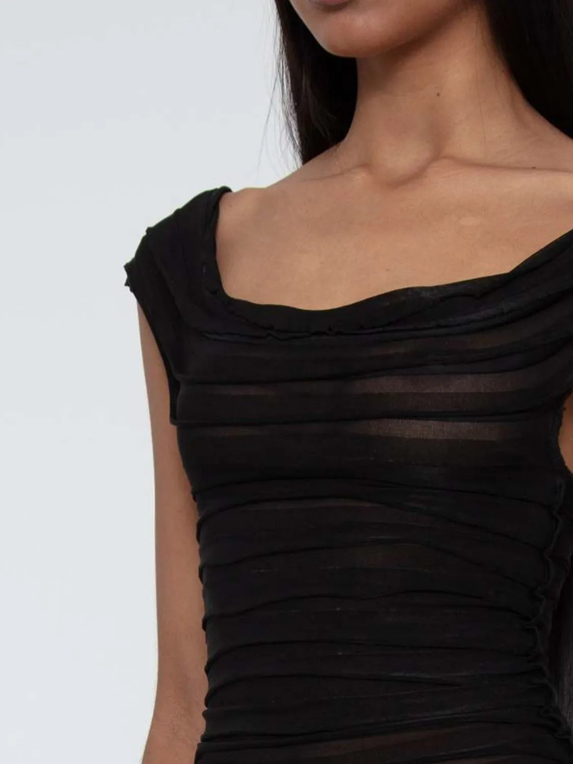 Black ruched sleeveless top on  woman with a white background