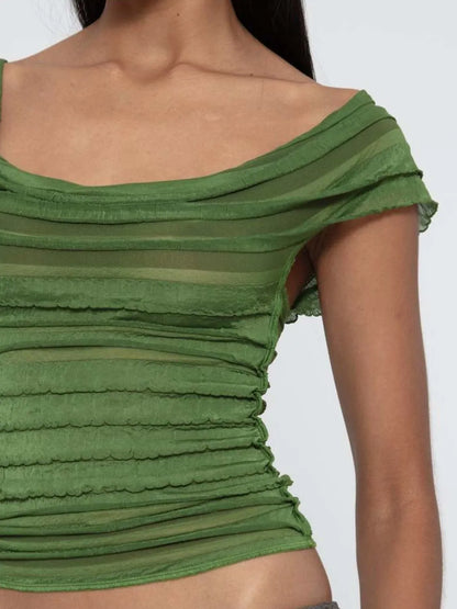 Green off-shoulder ruched top worn by a person on a white background