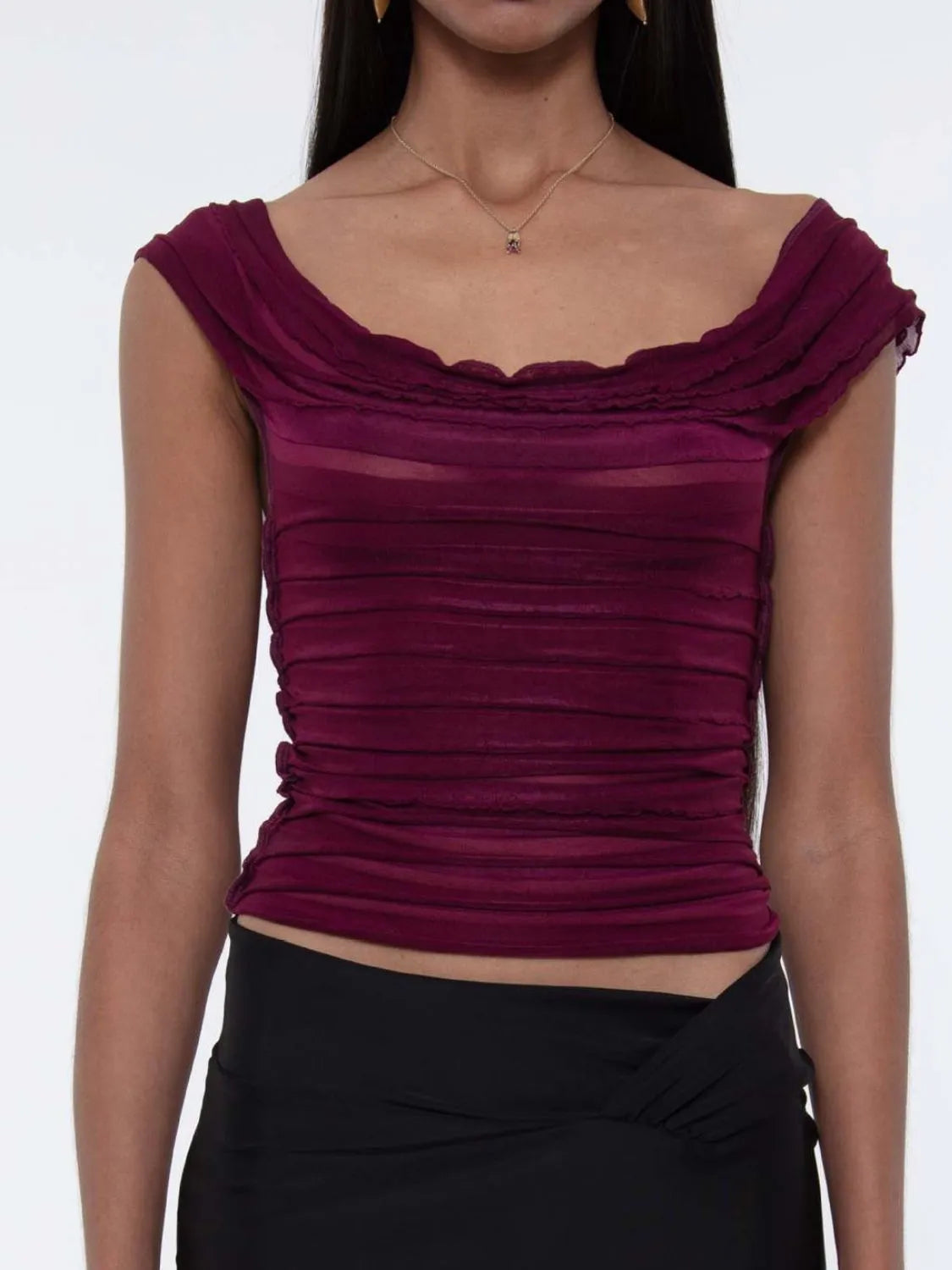 Purple  ruched sleeveless top worn by a woman on a white background