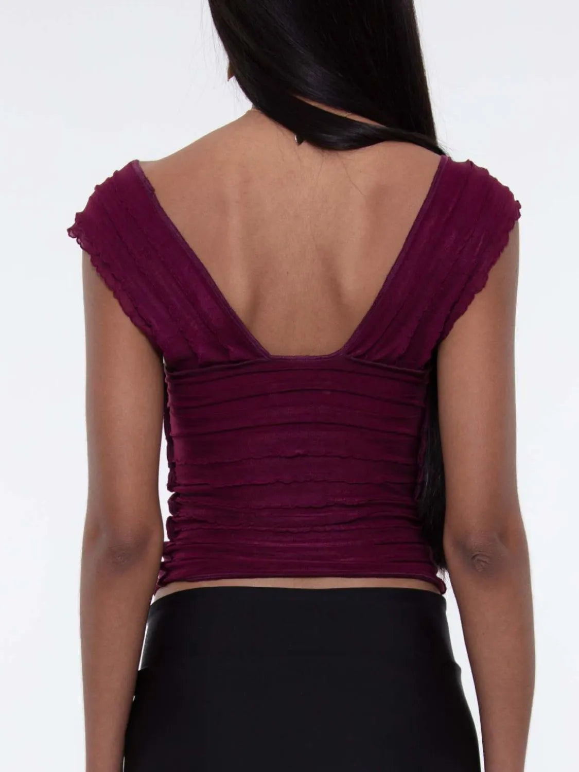 Purple ruched sleeveless top worn by a woman back view  on a white background