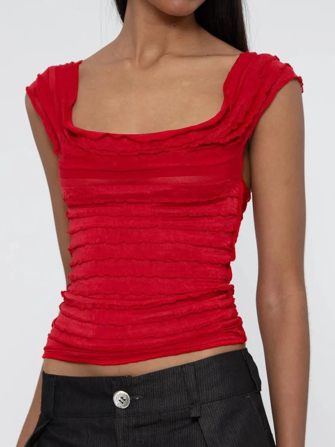 Red ruched sleeveless top worn by a woman on a white background