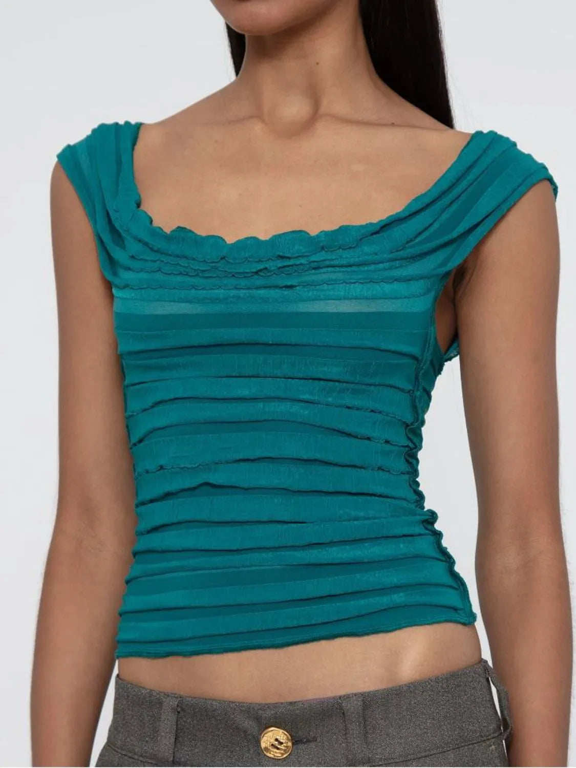 Teal ruched sleeveless top worn by a model on a plain background