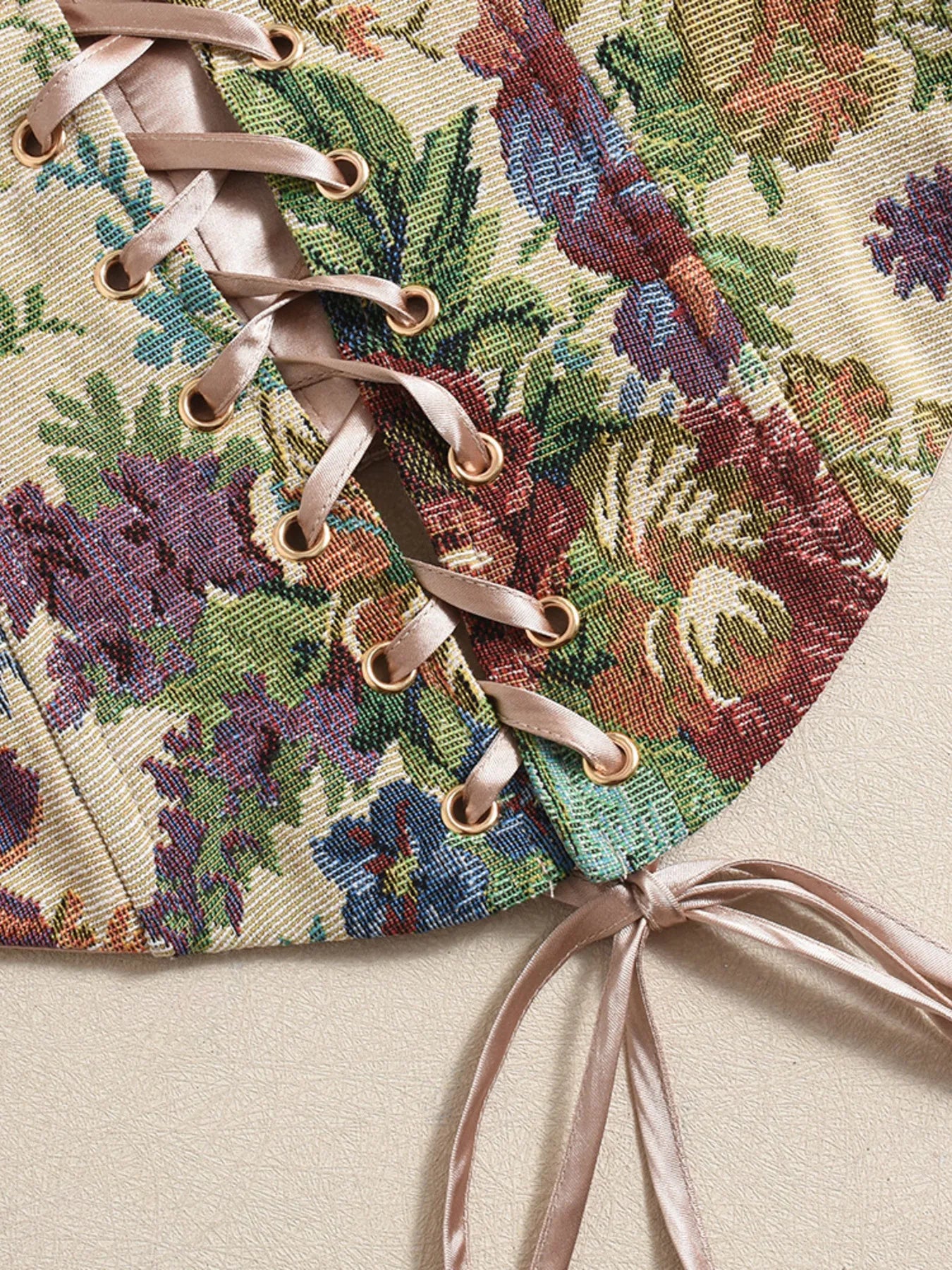 Close-up of a floral- summer tube top fabric with laces on a beige background