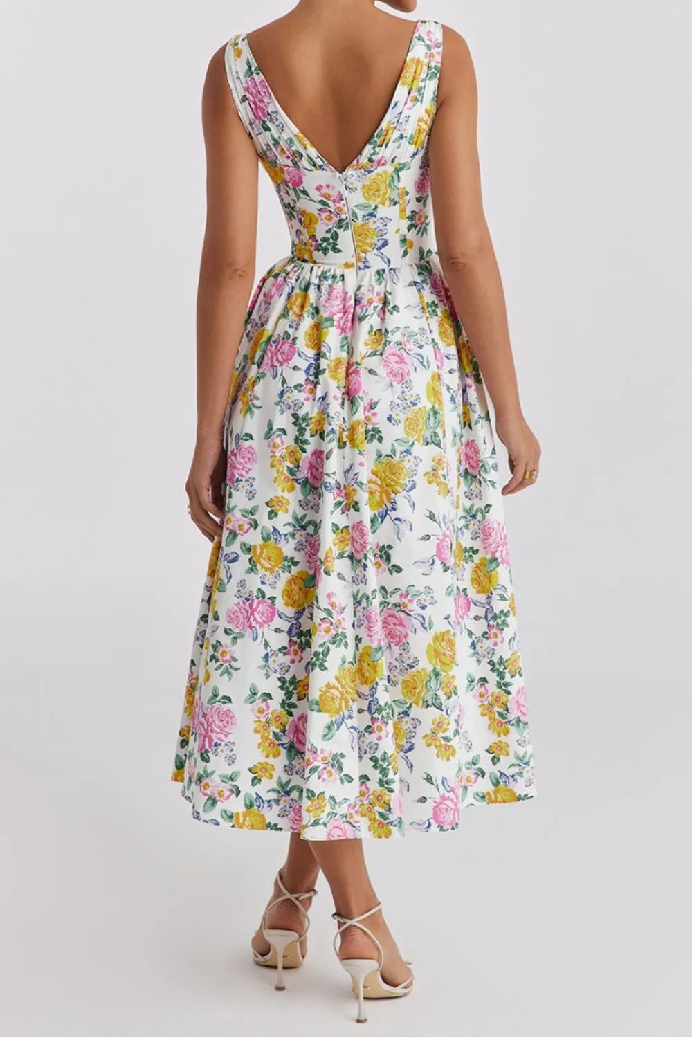 Woman wearing a vibrant multicolor floral v-neck sleeveless flowy midi dress  with pockets back view 