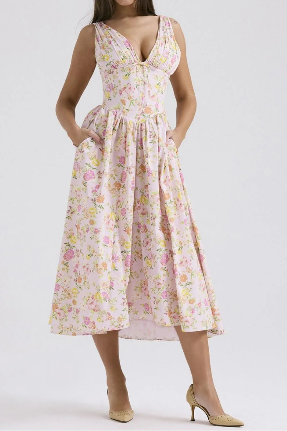 Woman wearing a Floral V‑neck sleeveless midi dress with pockets on a white background