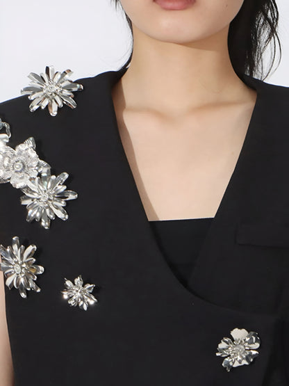 Close up of neckline of black high fashion blazer vest silver floral embellishments  for women on a plain background