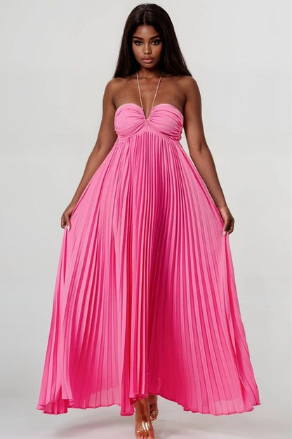 front view of elegant pink women’s pleated halter neck maxi dress for resort and evening events on model on a white background