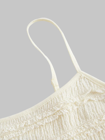 Close-up of a off white frill cami top on a beige background