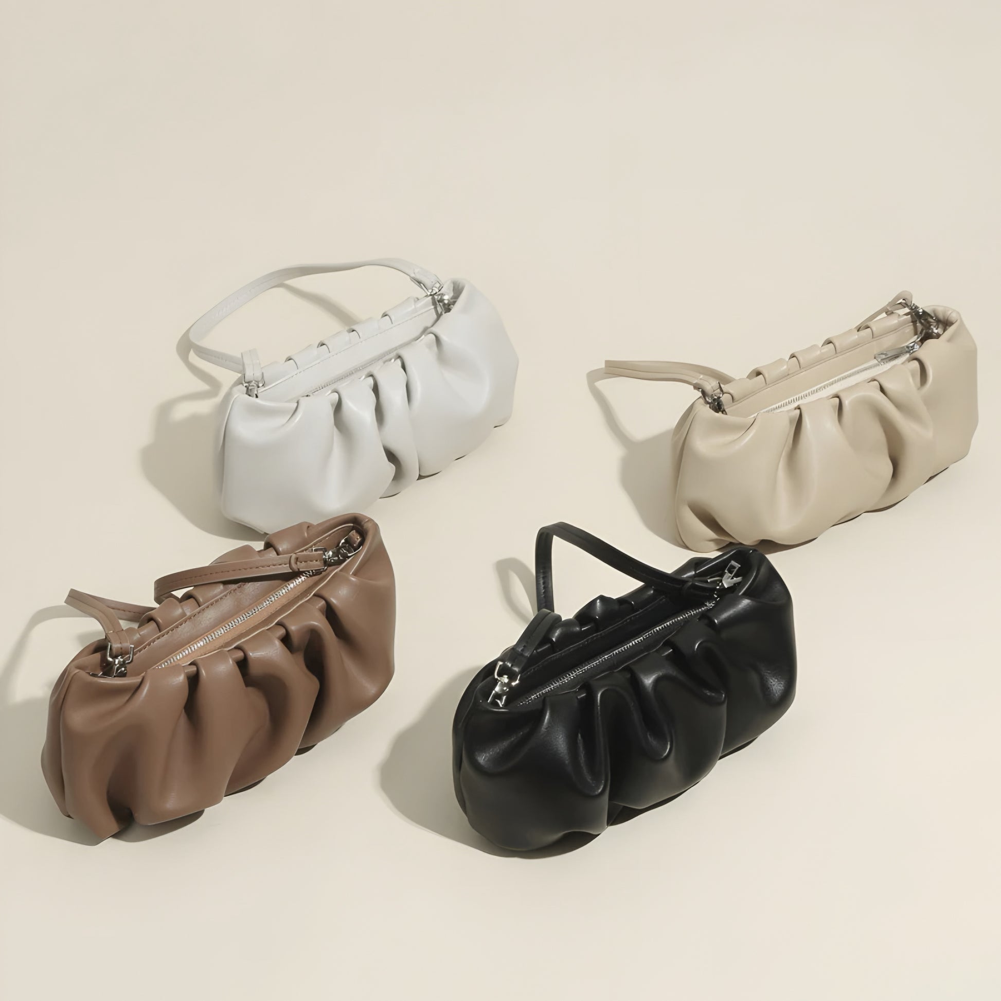 Genuine Leather Pleated Dumpling Bag in black, white, beige and brown on a beige background– luxury women’s handbag 