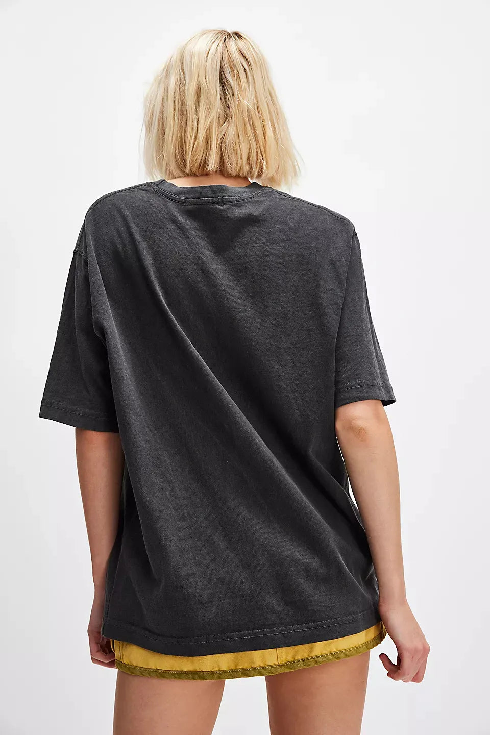 Back view of woman wearing a black t-shirt with sunflower design on a white background