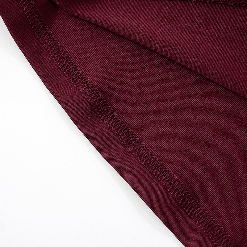 Close-up of hem of burgundy/red fabric of   Halter Backless Tulle  Maxi Dress on a white background