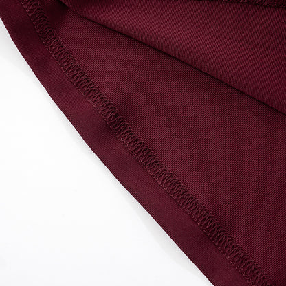 Close-up of hem of burgundy/red fabric of   Halter Backless Tulle  Maxi Dress on a white background
