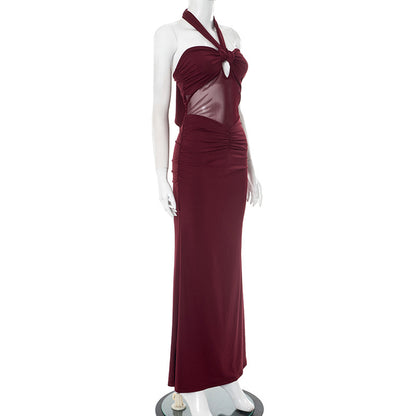 Side view of red/burgundy halter backless evening party dress with sheer bodice on a mannequin against a white background