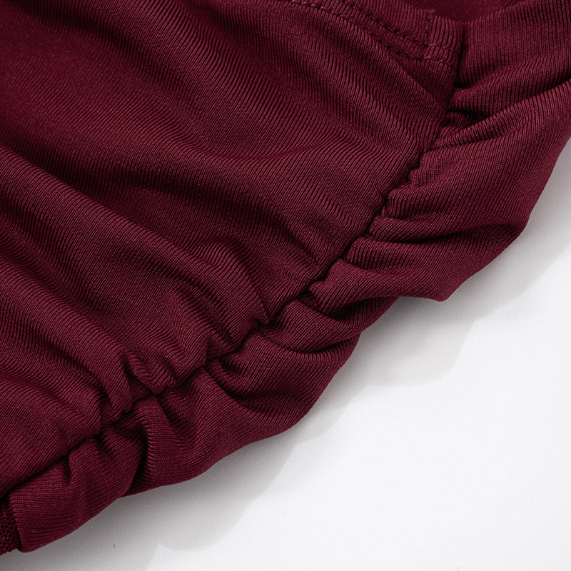 Close-up of burgundy/red scrunch of a Halter Backless Tulle maxi Dress on a white background