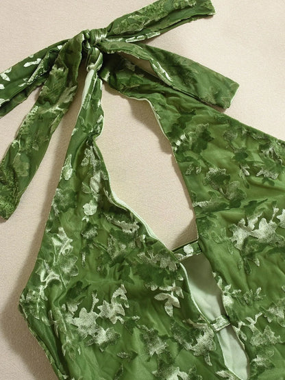 Green patterned halter neck midi dress neckline close-up view on a beige background