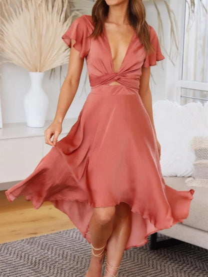 Model walking in coral high-low dress with flutter sleeves and deep v-neckline front view
