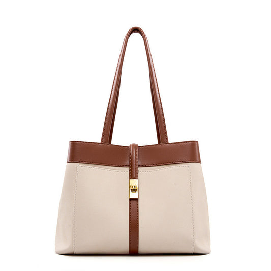 Beige shoulder bag with brown genuine leather contrast accents and gold clasp on a white background