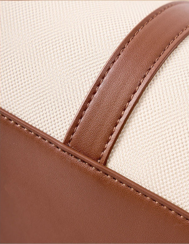Close-up of brown and beige genuine leather texture shoulder bag  with stitching details.