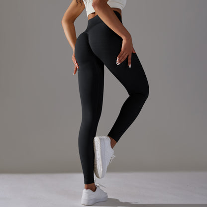 Model wearing high-waisted scrunch butt Black leggings with white sneakers, back view